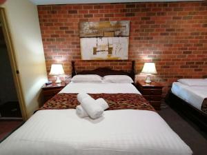 a hotel room with a bed and a dresser at Aussie Rest Motel in Cessnock