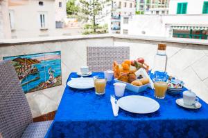 a blue table with a bowl of fruit and a bowl of juice at La Piazzetta in Amalfi