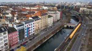 a city with a train on a bridge over a river at acama Hotel & Hostel Kreuzberg in Berlin