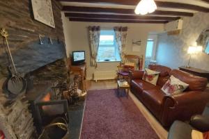 a living room with a couch and a fireplace at Self Catering Cottage in Talsarnau