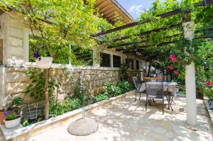 un patio con mesa y sillas bajo una pérgola en Camelia Luxury Apartments en Dubrovnik