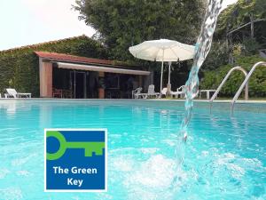 ルーゾにあるAlegre - Bussaco Boutique Hotelの傘付きのスイミングプールの噴水