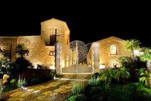 a large stone building with a courtyard at night at Borgo degli Angeli in Balestrate