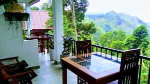a balcony with a table and chairs and a view of mountains at Ever Green Mount in Ella