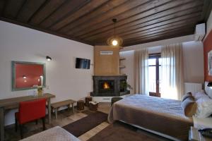 Un dormitorio con una cama y una chimenea. en ΜΠΑΡΟΥΤΟΜΥΛΟΣ -Baroutomilos, en Dhimitsana 25 fotos más