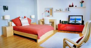 a bedroom with a bed and a television in it at Atlantic Suites Serviced Apartments in Gibraltar +19 photos