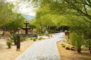 une passerelle dans un parc avec une fontaine et des arbres dans l'établissement La Casa Del Zorro Resort & Spa, à Borrego Springs