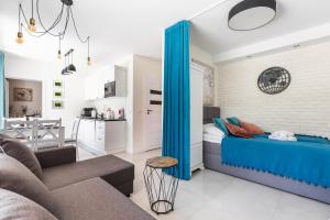 une chambre avec un lit bleu et un salon dans l'établissement Apartamenty Nosalowe Tarasy Zakopane, à Zakopane