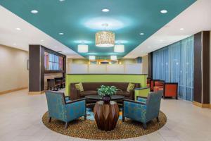 a lobby with a couch and a table and chairs at La Quinta by Wyndham Little Rock - West in Little Rock