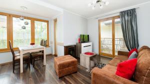 un soggiorno con divano e tavolo di Apartamenty Sun & Snow Poronin a Poronin