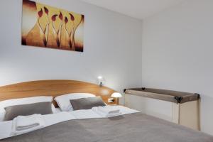 a bedroom with a large bed with a wooden headboard at J&M Spa Holiday Home Moravske Toplice in Moravske Toplice