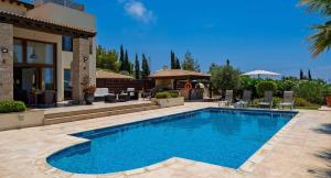 a swimming pool in front of a house at 4 bedroom Villa Lofou with private pool and sea views, Aphrodite Hills Resort in Kouklia