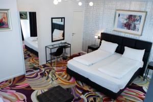 una camera con un grande letto e uno specchio di A Hotels City a Copenaghen