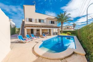 a swimming pool in front of a house at VILLA MANOLO DE L´ALZINA in Cala Millor