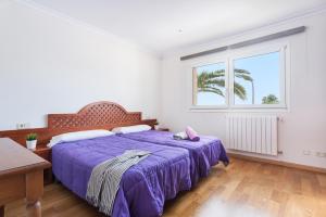 sypialnia z fioletowym łóżkiem i oknem w obiekcie VILLA MANOLO DE L´ALZINA w Cala Millor +25 zdjęć
