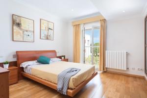 sypialnia z łóżkiem i dużym oknem w obiekcie VILLA MANOLO DE L´ALZINA w Cala Millor