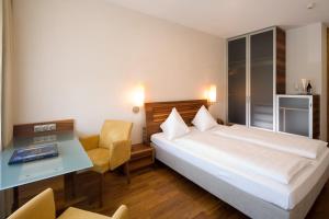 a hotel room with a bed and a desk at Hotel Penz West in Innsbruck