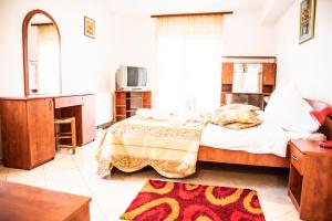 1 dormitorio con 1 cama grande y TV en Club Onix Apartments, en Neptun