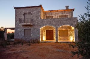 a stone house with lights on the front of it at The three houses in Kalamata