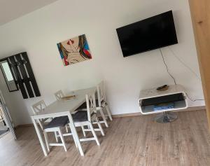 a living room with a table and a tv on a wall at Apartment 4 - Gourmetzimmer in Bestensee