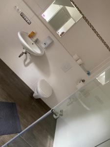 a bathroom with a sink and a toilet and a mirror at Apartment 4 - Gourmetzimmer in Bestensee