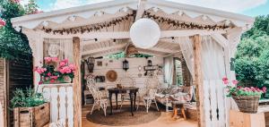 een witte pergola met een tafel en stoelen bij Ferienwohnung Rosenheim in Wagenham