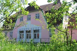 a pink house with a sign in front of it at Ferienhaus Kastaniengrün in Worpswede +8 photos