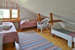 Cette chambre mansardée comprend deux lits et une chaise. dans l'établissement Hyvölän Talo, à Ähtäri