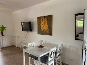 a white dining room with a white table and chairs at Apartment 5 - Gourmetzimmer in Bestensee