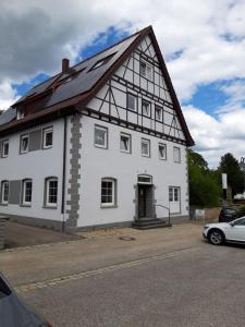 a large white building with a gambrel roof at Pension Deckenpfronn in Deckenpfronn