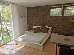 um quarto com uma cama e uma parede de tijolos em Lou Pauseto em Aubagne