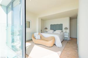 een slaapkamer met een bed, een stoel en een raam bij The Beach House at Sandgate by Bloom Stays in Sandgate