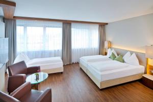a hotel room with a bed and a couch at Hotel Penz West in Innsbruck
