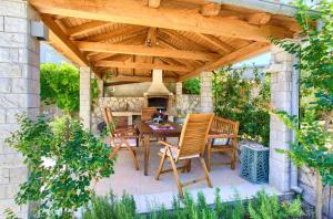 a patio with a table and chairs under a wooden pergola at Holiday Home Lavanda in Kornić