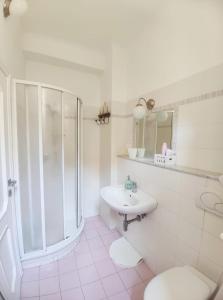 ein weißes Bad mit einer Dusche und einem Waschbecken in der Unterkunft Chez Tamara with private parking and air conditioned in Monterosso al Mare