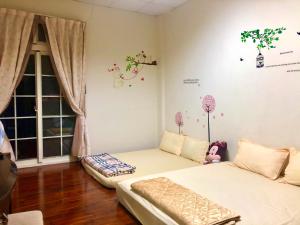 sypialnia z 2 łóżkami i oknem w obiekcie Yuan Fang Homestay w mieście Fanlu