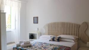 Schlafzimmer mit einem Bett mit einem Kopfteil aus Holz und einem Fenster in der Unterkunft Chez Tamara with private parking and air conditioned in Monterosso al Mare