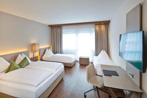 a hotel room with a bed and a flat screen tv at Hotel Penz West in Innsbruck