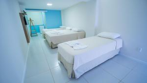 twee bedden in een kamer met blauwe verlichting bij Nordeste Palace Hotel in Fortaleza