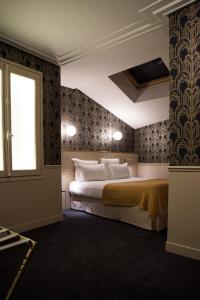 een slaapkamer met een bed en een raam bij Hôtel Léna in Parijs