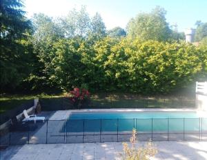 Bartrés的住宿－Villa PARADISE，一个带围栏和树木的庭院内的游泳池