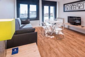 salon z kanapą i stołem w obiekcie Apartments Playa de Castelldefels w mieście Castelldefels