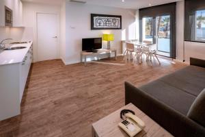 kuchnia i salon z kanapą i stołem w obiekcie Apartments Playa de Castelldefels w mieście Castelldefels