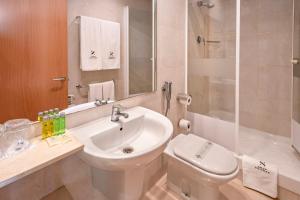 biała łazienka z umywalką i toaletą w obiekcie Apartments Playa de Castelldefels w mieście Castelldefels +26 zdjęć
