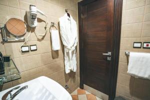 a bathroom with a toilet and a sink and a door at Platinum Seventy in Jeddah