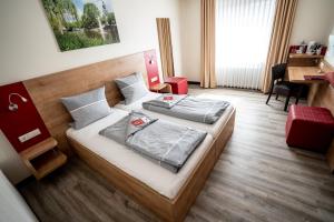 a bedroom with two beds and a desk at INSIDE Hotel Nordhorn in Nordhorn