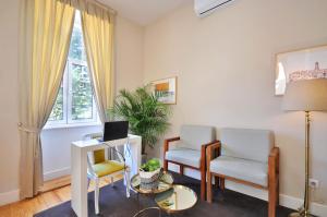 een woonkamer met 2 stoelen en een bureau met een laptop bij Porto Charming Hotel in Porto