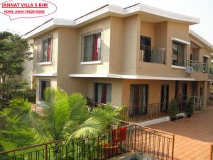 a large house with a palm tree in front of it at JANNAT VILLA in Lonavala