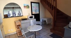 a kitchen with a small table and a microwave at Le gîte de l'atelier in Lailly-en-Val