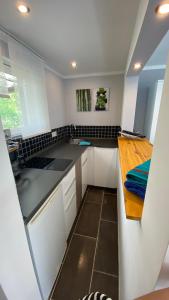 a kitchen with white cabinets and black counter tops at Das Ferienhaus am Tiergarten in Wernigerode